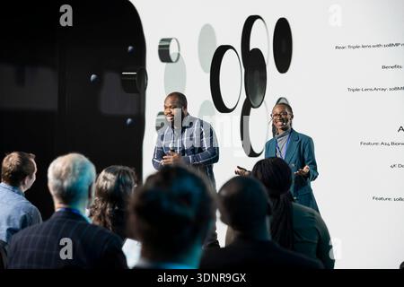 Black product engineering team gives new product presentation for mobile tech, modern phone design coming soon. Innovation and marketing with smartphone release at launch event. Stock Photo