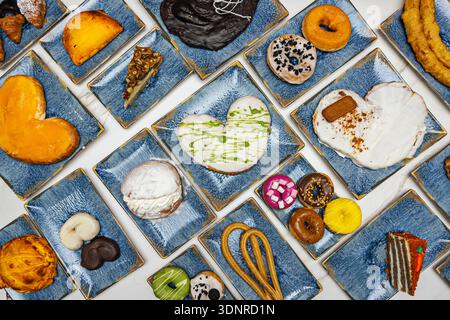 A classic still life with a profusion of sweets on a marble table, illuminated by light that accentuates their textures and shine. Stock Photo