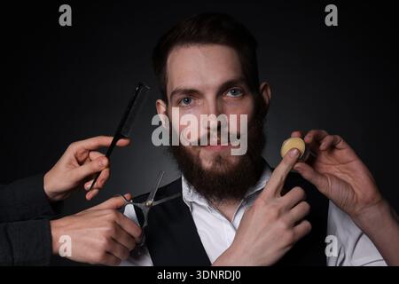 Man and barber with tools on black background Stock Photo