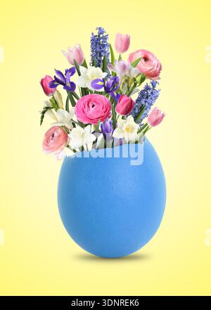 Easter card with spring flowers in broken eggshell on beige background Stock Photo