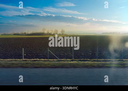 View of nature through the car window while traveling, dramatic scenes of central Serbia during the snowless winter period. Stock Photo