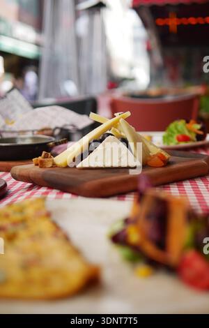 Delicious food served on a wooden board in a busy restaurant Stock Photo