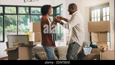 Moving, dancing and mature couple in new home with boxes for bonding, love and fun together. Happy, marriage and man with woman for groove with Stock Photo