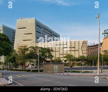 Modern Suasana PjH building in Putrajaya, Malaysia, featuring unique architecture, a clear blue sky, and a street with lush trees Stock Photo
