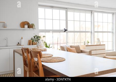 Interior of kitchen with table, sofa and large window Stock Photo