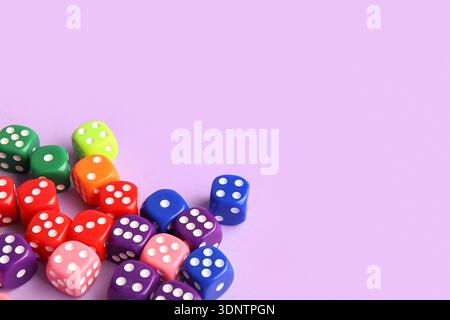 Colorful game dices on lilac background, closeup Stock Photo
