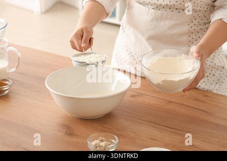 Woman preparing traditional cinnamon rolls in kitchen Stock Photo