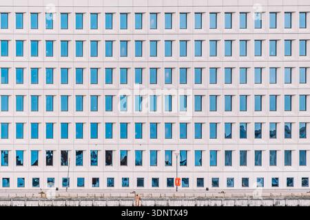 Modern Building Facade with Repetitive Blue Glass Windows Pattern, Minimalist Urban Architecture Stock Photo
