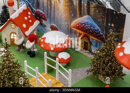 Overhead view of a charming Christmas holiday display featuring two gnomes, whimsical mushroom houses, and illuminated trees, evoking a festive winter Stock Photo