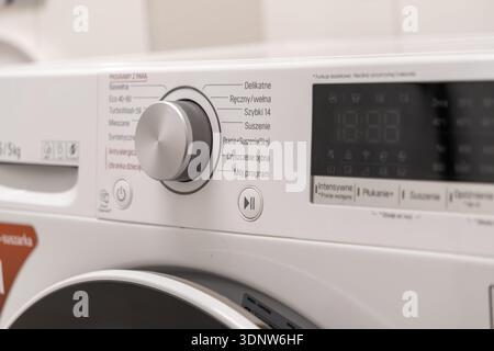Close-up of a contemporary laundry appliance interface, featuring a sleek silver dial and clear display, symbolizing convenience, domestic technology, Stock Photo