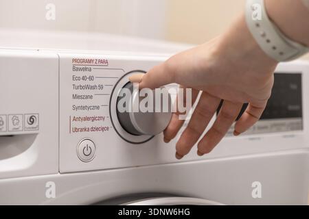 Close-up of a person selecting the specialized Antiallergic or Baby clothes setting on a modern washing machine, ensuring hygienic and gentle laundry Stock Photo