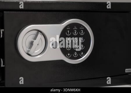 Detailed view of a modern black electronic safe, highlighting its digital keypad and status indicators for secure document and valuable personal item Stock Photo