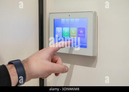 Top view of a person using a smart home video door phone, navigating its interactive screen for comprehensive residential security and communication s Stock Photo