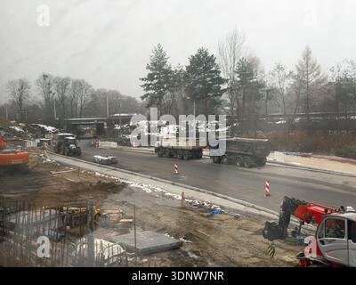 Gliwice, Poland - November 30, 2025: Elevated view of a winter construction site featuring heavy earthmoving machinery and dump trucks building crucia Stock Photo