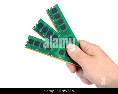 A hand holds four memory sticks showing DRAM technology. The focus is on the design and layout of the memory modules. Stock Photo