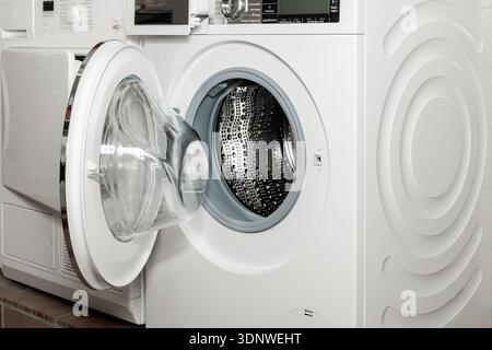 Open modern wifi washing machine closeup in special service room in house. Stock Photo