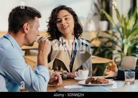 Coworkers enjoying coffee break discussing business at cafe Stock Photo