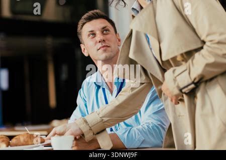 Coworkers taking coffee break with snack and talking Stock Photo