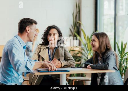 Diverse coworkers on coffee break discussing business and collaborating Stock Photo