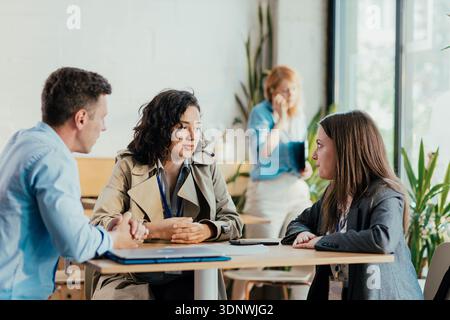 Diverse coworkers collaborating during office coffee break discussion Stock Photo