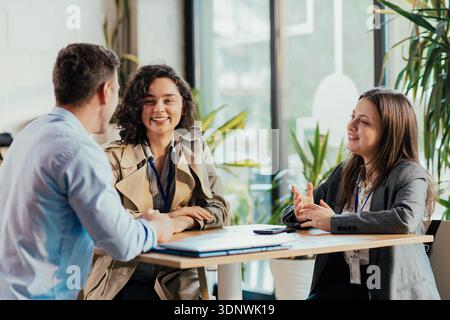 Coworkers collaborating and smiling during a business meeting Stock Photo