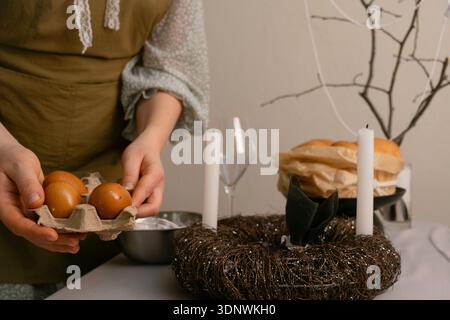 Warm Easter moment, decorating the table with candles and painted eggs, creating a cozy atmosphere for family celebration. Stock Photo