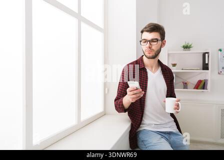 Confident modern businessman standing at office near window Stock Photo