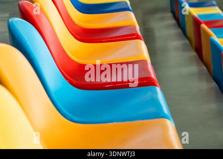 Colourful plastic stadium seats forming diagonal abstract pattern Stock Photo