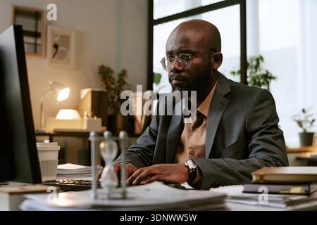 Black Man Working at Desk in Modern Office Environment Stock Photo