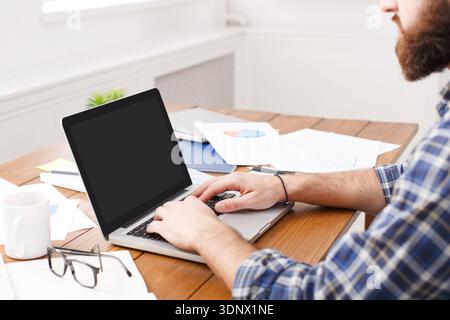 Young businessman working with laptop in modern white office Stock Photo