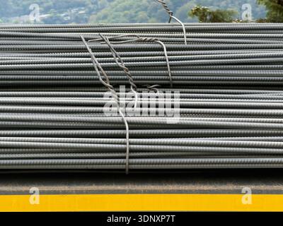 Bundled steel rebar rods stacked in an orderly fashion, ready for construction use. The image captures the industrial detail with a serene natural bac Stock Photo