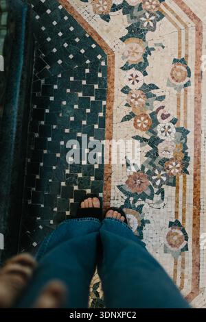 A person stands on a decorative mosaic tile floor in a Las Vegas casino motel, highlighting intricate floral and geometric patterns underfoot, combini Stock Photo