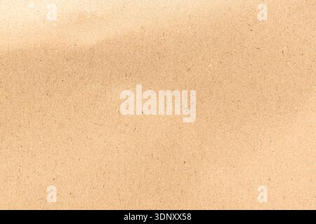 A close-up view of a kraft paper texture, showcasing a natural, recycled look. The warm brown color and subtle fibers create an organic, earthy backgr Stock Photo