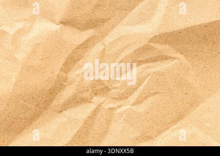 A high-resolution image of kraft paper showcasing its natural texture and subtle wrinkles. The earthy brown tone adds warmth, making it perfect for ba Stock Photo
