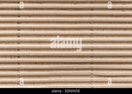 Close-up of a brown corrugated cardboard texture, showcasing its ridged surface. Ideal for backgrounds in design projects needing an organic and indus Stock Photo