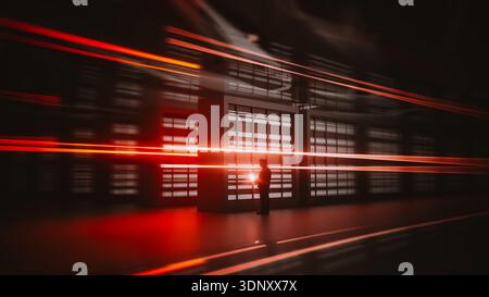 A technician is engaged with a laptop inside a cutting-edge data center. Bright lights create a dynamic atmosphere filled with technology. Stock Photo