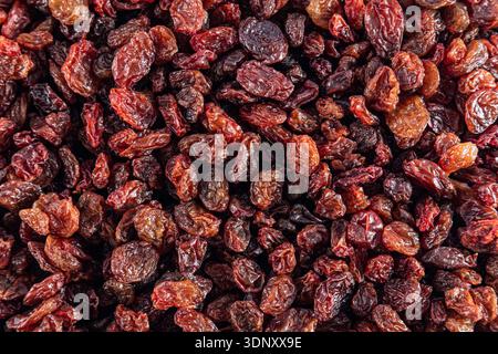 Top view of a dried fruit background featuring an abundance of red raisins. The varying shades of red and brown create a rich, textured composition on Stock Photo