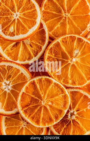 Top view of dried orange slices showcasing vibrant hues and intricate textures. The slices are layered, revealing the detailed patterns of citrus Stock Photo