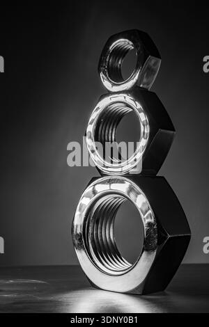 Large industrial nuts stacked with a dark background Stock Photo