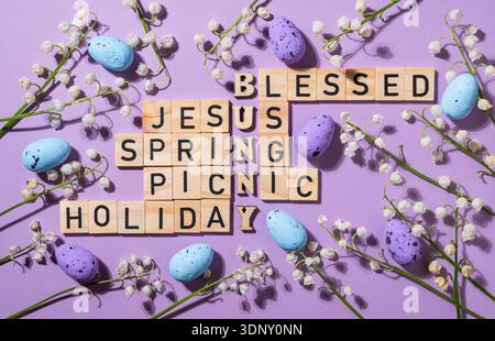 A creative Easter themed crossword puzzle using wooden blocks, featuring words like Jesus, spring, and bunny. Surrounded by flowers and colored eggs o Stock Photo