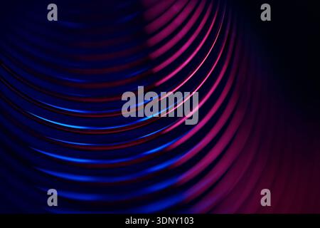 Abstract image featuring neon spiral shapes with glowing blue and red curves. The metal-like spirals create a dynamic, futuristic design on a dark bac Stock Photo
