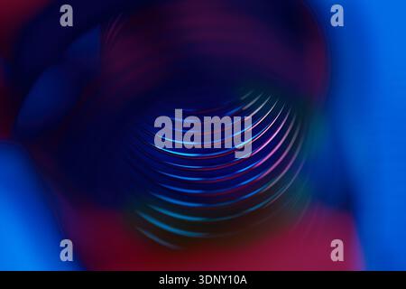 A visually striking abstract image featuring neon spiral shapes with a metallic texture. The composition uses vibrant blue and red colors to create a Stock Photo