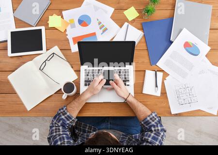 Top view young businessman sitting at the table with mobile phone, view from above Stock Photo