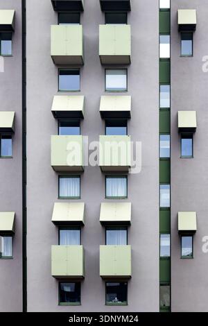 abstract Facade of a modern residential building featuring repeating pattern of small balconies and windows with awnings berlin germany Stock Photo