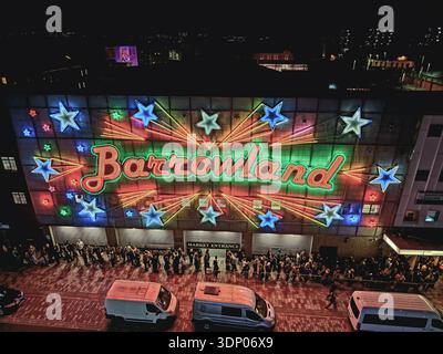Crowds gathered outside the Barrowland Ballroom at night in Glasgow, Scotland, with illuminated neon signage on the famous music venue façade. Stock Photo