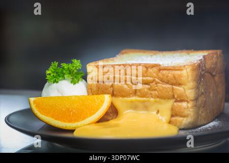 orange toast with icecream on black dish Stock Photo