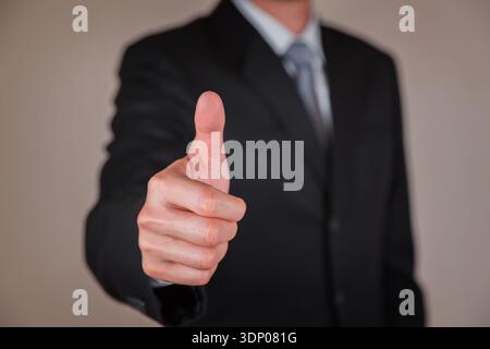 Businessman give a thumbs up for compliment as praise, congratulate, good and like concept. Stock Photo