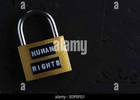 High contrast view of closed lock on black textured surface. Concept of censorship or strict law Stock Photo