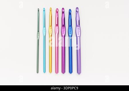 Colorful Crochet Hooks in a Row on White Table, Top View Flat Lay Stock Photo