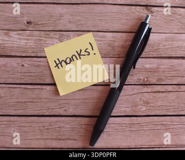 Post-It with "Thank You" and Black Pen on Wooden Table, Top View Flat Lay Stock Photo